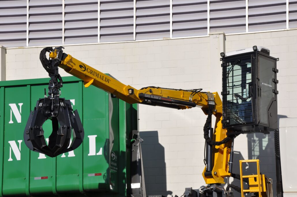 a yellow crane with a green container